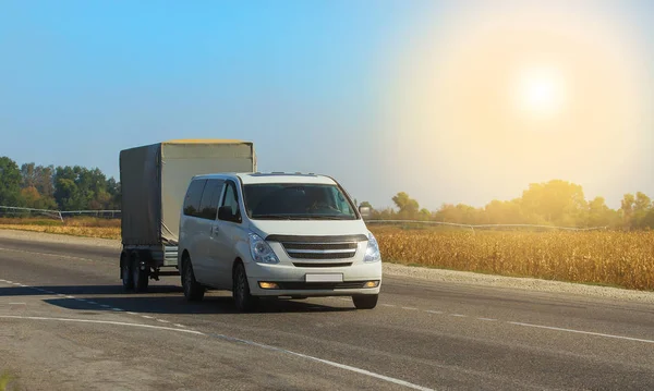 Minivan mit Anhänger. Bewegung auf einer Vorstadtautobahn — Stockfoto