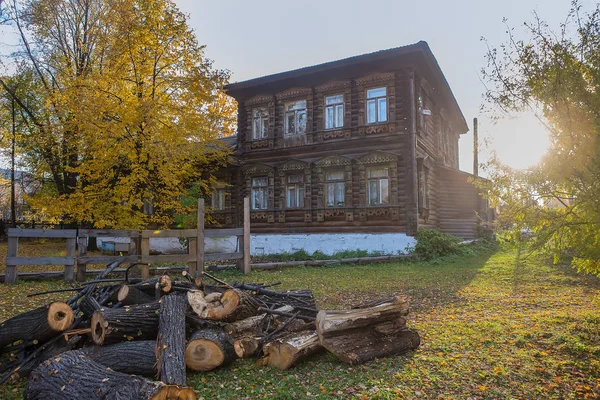 Двухэтажный бревенчатый дом и палисадник на закате осени — стоковое фото