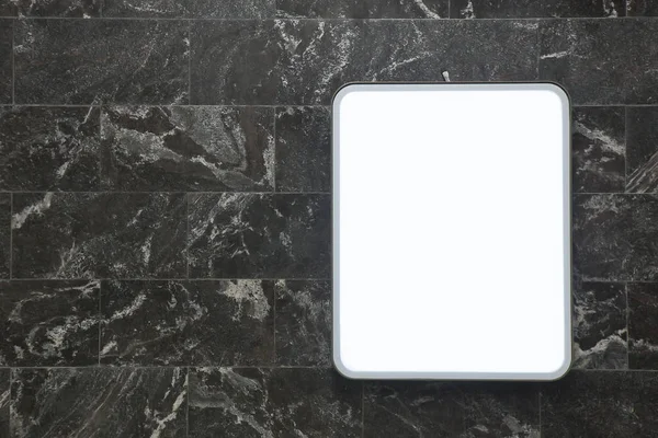 Pannello informativo chiaro sulla parete di piastrelle in marmo scuro — Foto Stock
