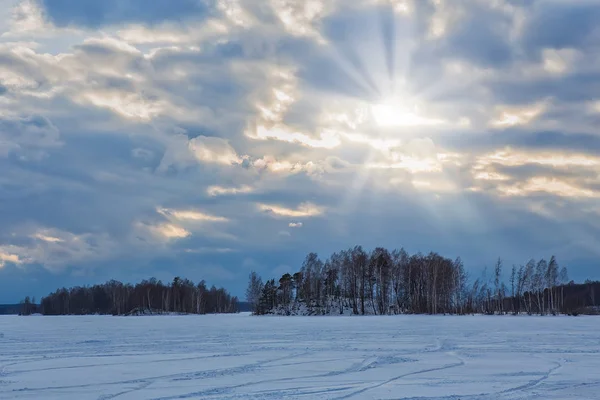 Sunset over the lake covered with ice in winter — Stok fotoğraf