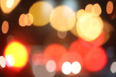 Karanlık bir arkaplanda soyut bir bulanıklık. Koyu arkaplanda yuvarlak renkli ışık noktaları.