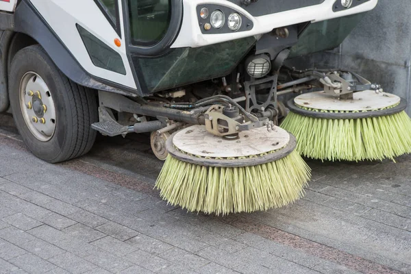 car for cleaning streets with rotating round brushes. Close-up, detail.