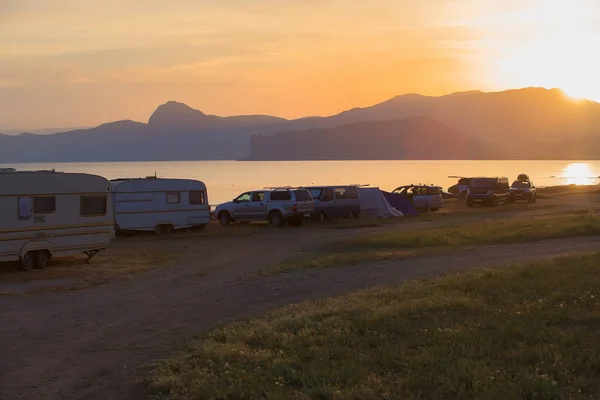 夏は日没時に海沿いのキャンプ場で車やキャンプトレーラー — ストック写真