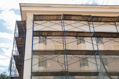 Restoration of the facade of an old building with beautiful stucco molding on the walls