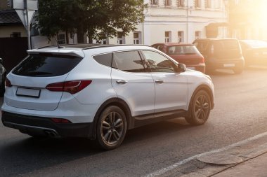 SUV gün batımında şehir caddesinde hareket eder.