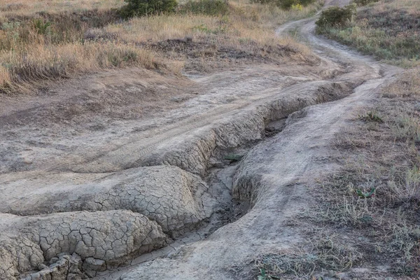 大雨で流された畑の中を通れない未舗装の道路 — ストック写真