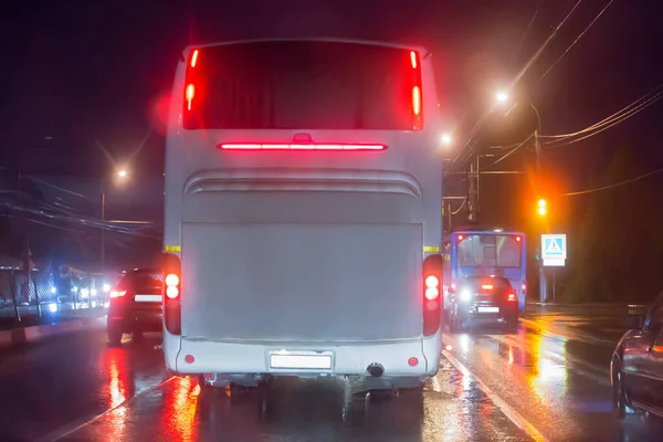 bus moves at night in the rain on a city street