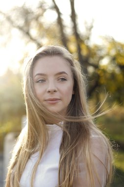 Sıcak güneşin altında uzun sarı saçlı güzel bir kız.