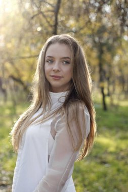 Sıcak güneşin altında uzun sarı saçlı tatlı bir kız.