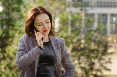 Cep telefonuyla konuşan genç bir kadın.