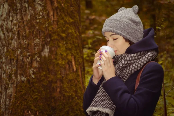 Genç bayan sıcak kahve içiyor. 