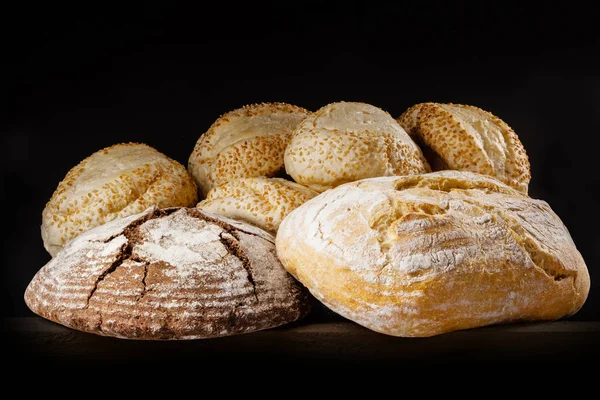 Pane fresco e focacce con sesamo su fondo scuro . — Foto Stock