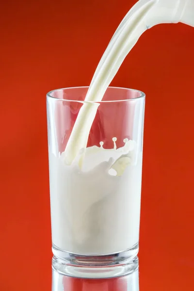 Kırmızı Üzerine Süt Sıçraması — Stok fotoğraf