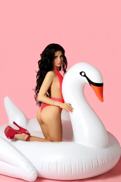 Hermosa chica en traje de baño en el colchón inflable en forma de un cisne — Foto de Stock