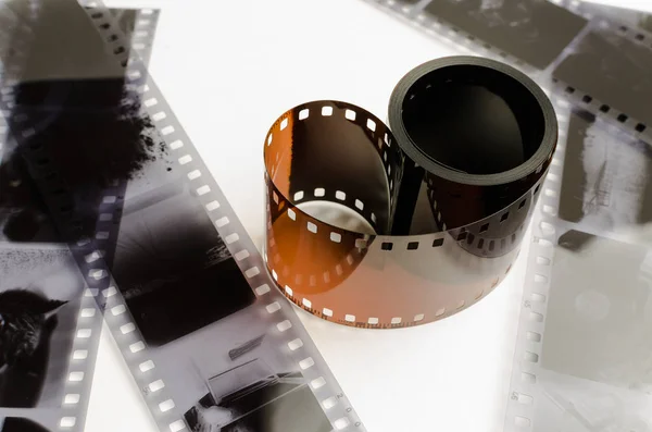 O rolo de 35 mm filme sobre fundo branco, preto e branco negativos — Fotografia de Stock