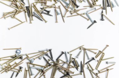 Beyaz arka planda metal vidalar yığını