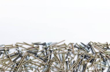 Beyaz arka planda metal vidalar yığını