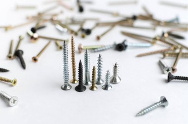 Beyaz arka planda metal vidalar yığını