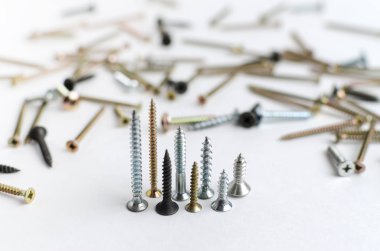 Beyaz arka planda metal vidalar yığını