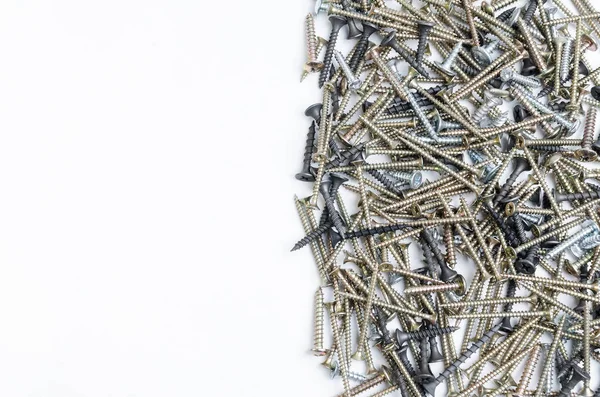 Beyaz arka planda metal vidalar yığını