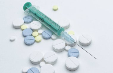 renkli tablet ve beyaz arka planda, closeup tek kullanımlık şırınga