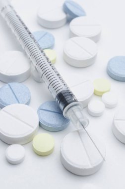 renkli tablet ve beyaz arka planda, closeup tek kullanımlık şırınga