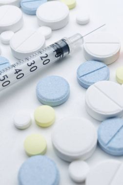 renkli tablet ve beyaz arka planda, closeup tek kullanımlık şırınga
