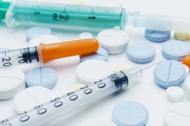 renkli tablet ve beyaz arka planda, closeup tek kullanımlık şırınga