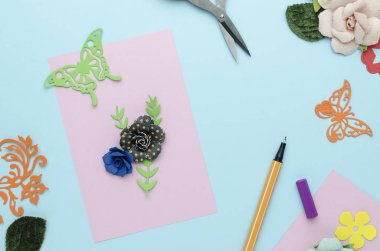 Kağıt çiçekler üzerinde mavi arka plan ile parlak pembe kartpostal