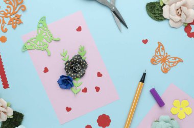 Kağıt çiçek ve kelebek, mavi arka plan ile parlak pembe kart