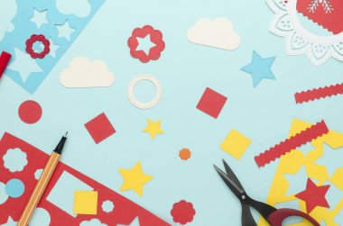 mavi bir arka plan üzerinde dağınık renkli kağıt kesim basit geometrik şekiller