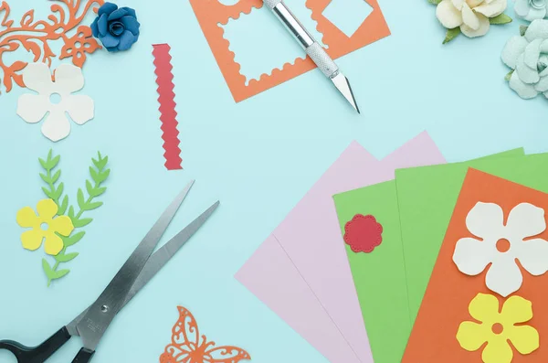 scissors, colored paper, cut out shapes and flowers