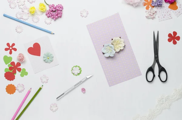 Kağıt çiçekler, makas ve beyaz arka plan üzerinde renkli kalemler. Scrapbooking. Üstten Görünüm.