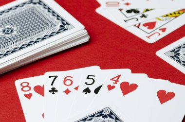 Kırmızı bir arka plan üzerinde iskambil. Birlikte Poker, sokak