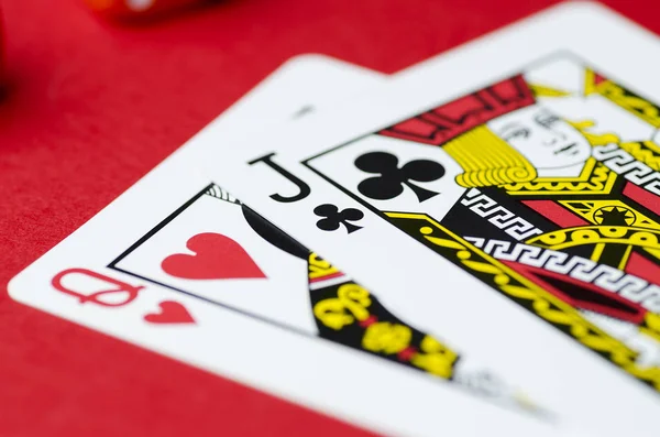 Two cards of spades and the Jack on a red background. Soft focus, close-up
