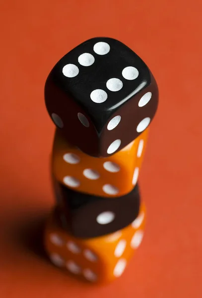 four dice red and black in column on red background close up