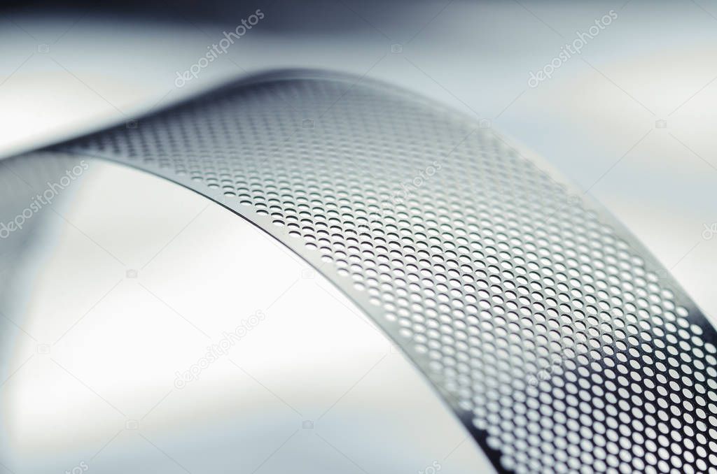 Metal perforated tape, close-up abstract
