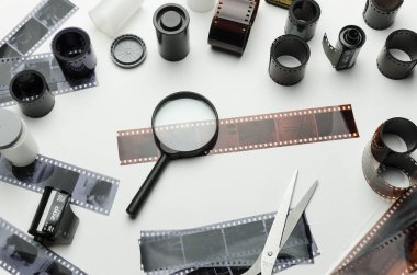 Film, film rulo, negatifleri ve beyaz arka plan üzerinde büyüteç