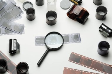 35mm film ve beyaz arka plan üzerinde büyüteç