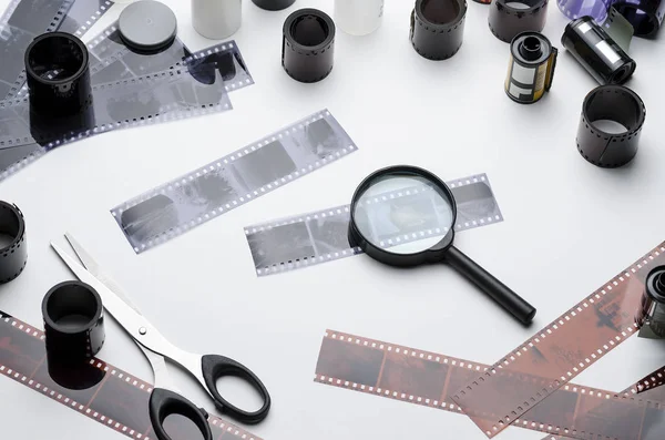 Film, film makaraları, makas ve beyaz arka plan üzerinde büyüteç