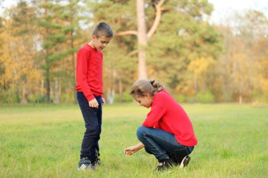 Bir erkek bir kızla bir sonbahar Park'ta yürüyordunuz