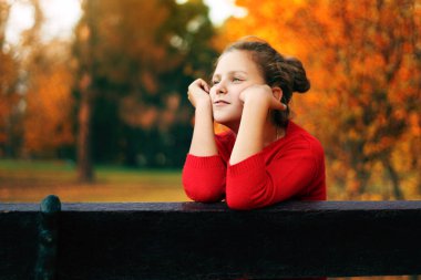 Bir kız parkta bir bankta oturuyor