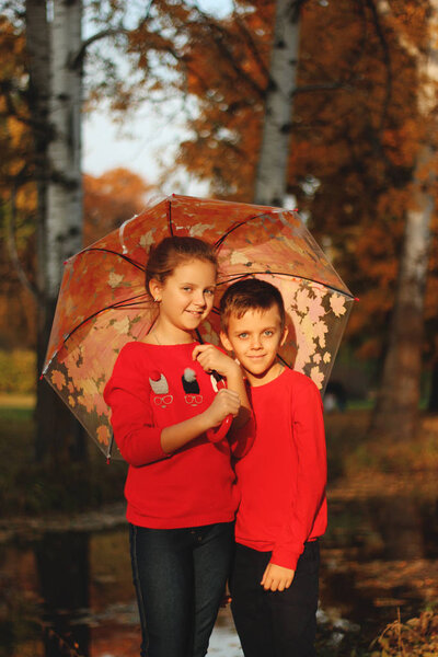 A boy with a girl holding an umbrella