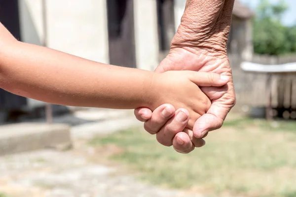 Mãos jovens seguradas por mãos velhas — Fotografia de Stock