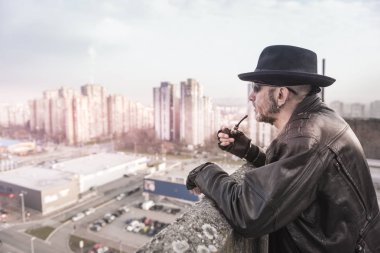 Yasaktır boru tutarak ve cityscape çatıdan seçici odak arayan adam 