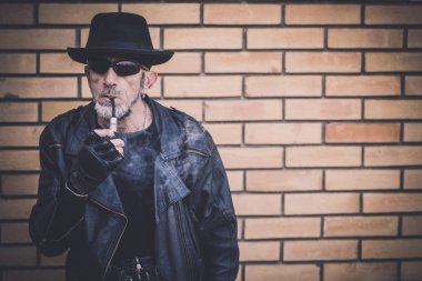 Şık erkek portre yasaktır boru kırmızı tuğla arka planda, seçici odak ile 