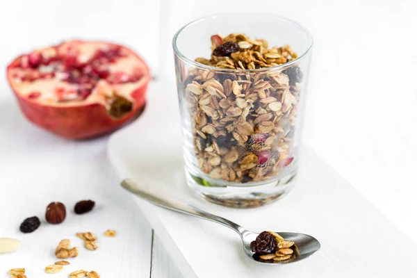 Domácí granola ve sklenici s granátovým jablkem na bílém stole — Stock fotografie