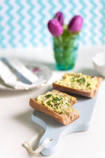 Sandwich de baguette crujiente con huevo extendido en la tabla de cortar — Foto de Stock
