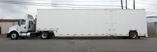 Trucking Industry: Side view of parked long white semi.