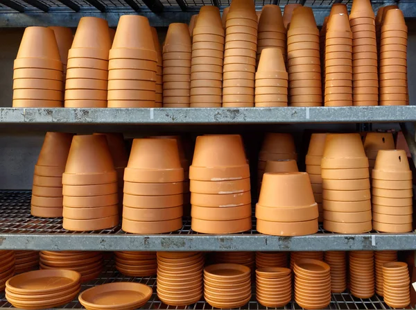 Planters: Shelves filled with terra cotta pots.